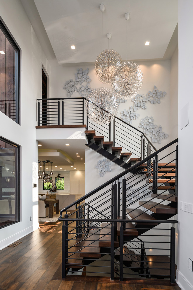 Design ideas for a contemporary wood floating wire cable railing staircase with open risers.