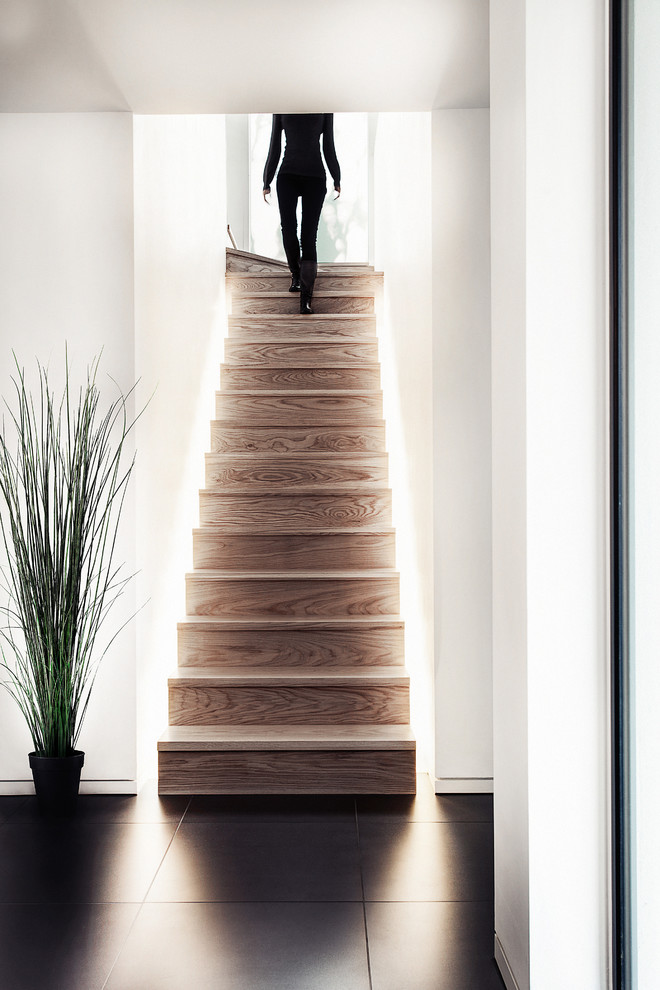 Example of a trendy wooden staircase design in Hampshire with wooden risers