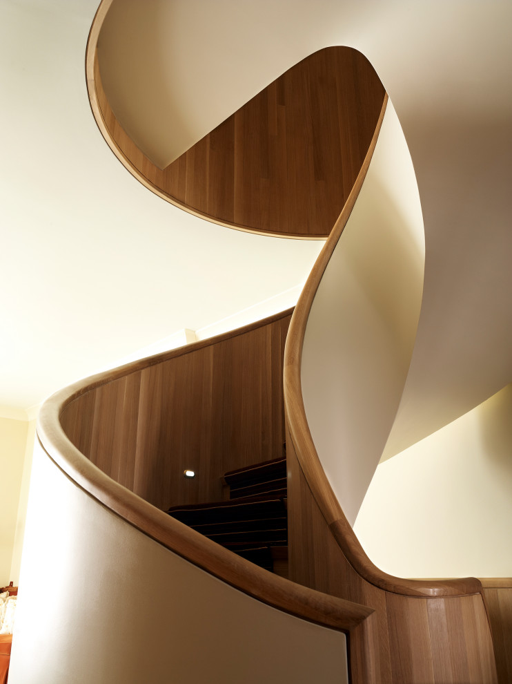 Aménagement d'un escalier hélicoïdal contemporain avec des marches en moquette, des contremarches en moquette et un garde-corps en matériaux mixtes.