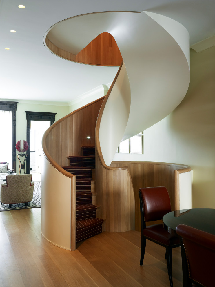 Свежая идея для дизайна: винтовая лестница в современном стиле с ступенями с ковровым покрытием, ковровыми подступенками и перилами из смешанных материалов - отличное фото интерьера