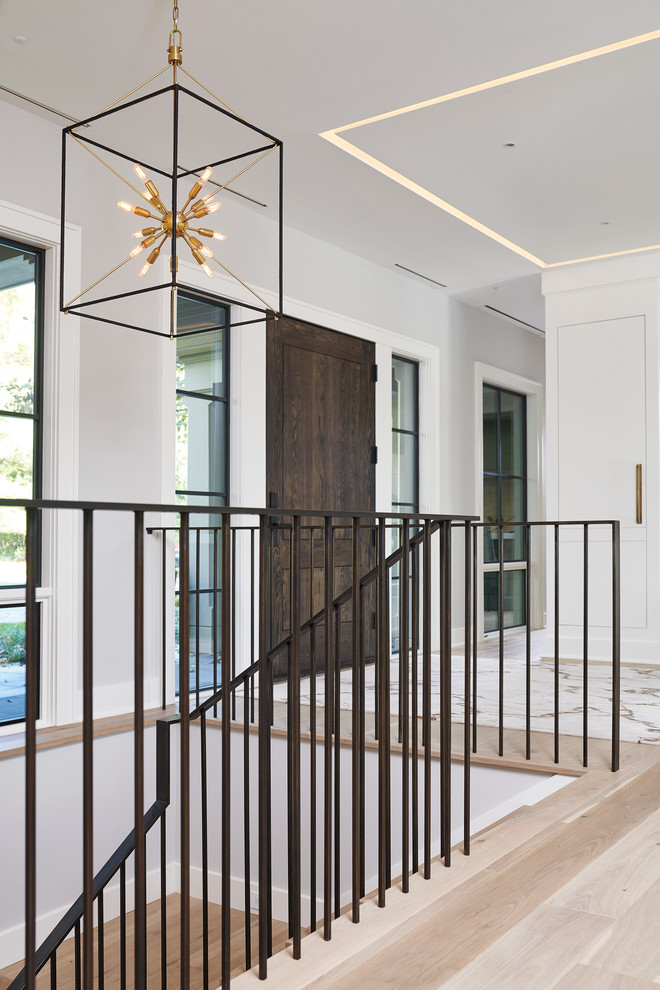 Design ideas for a large classic wood u-shaped metal railing staircase in Grand Rapids with wood risers.