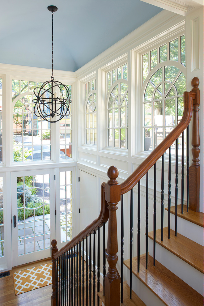 This is an example of a large victorian wood l-shaped staircase in Boston with painted wood risers.