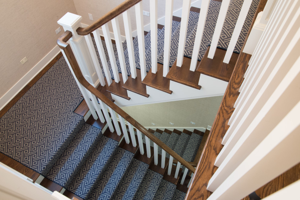 Ejemplo de escalera en U de estilo americano pequeña con escalones de madera, contrahuellas enmoquetadas, barandilla de madera y papel pintado