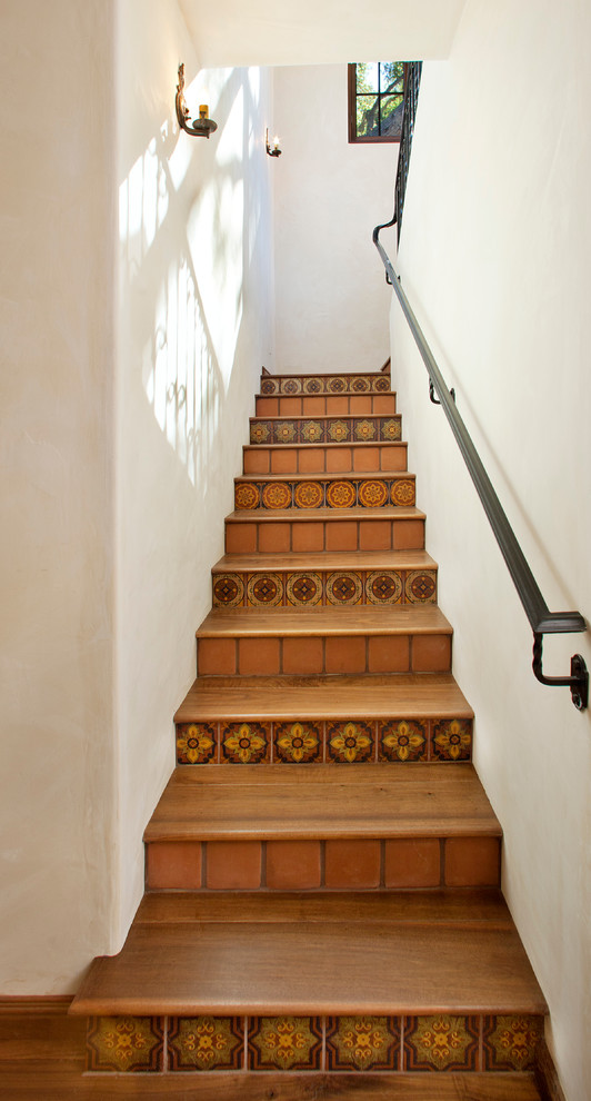 Источник вдохновения для домашнего уюта: лестница в средиземноморском стиле с деревянными ступенями, металлическими перилами и подступенками из терракотовой плитки