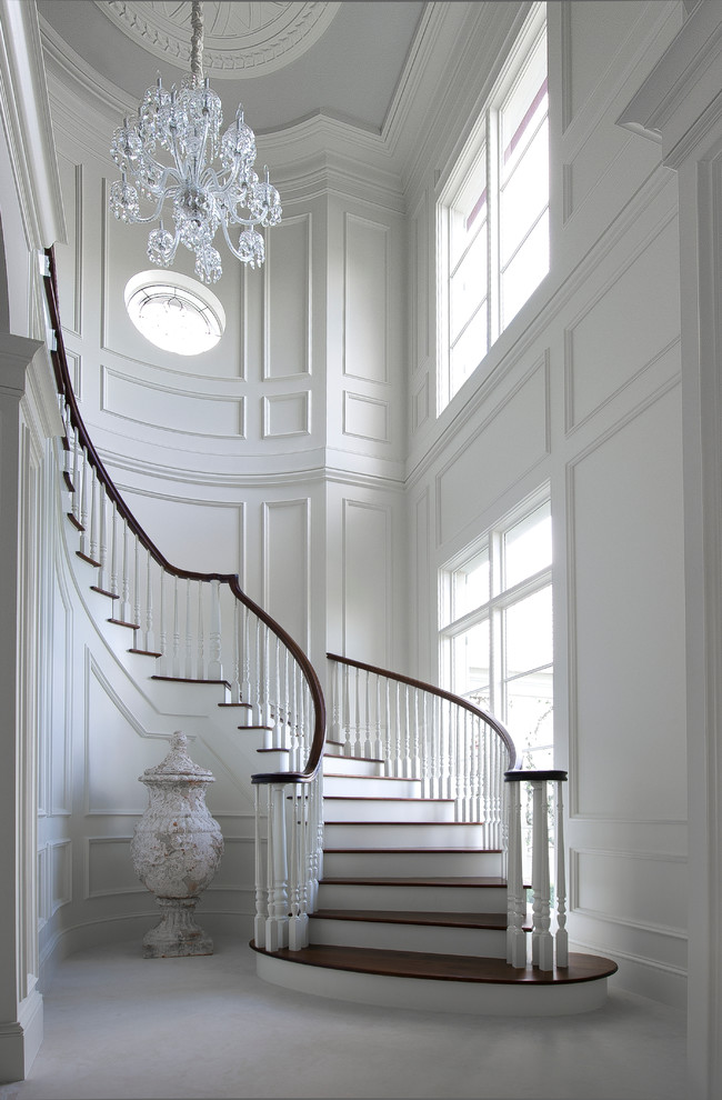 Idées déco pour un grand escalier peint courbe classique avec des marches en bois et éclairage.