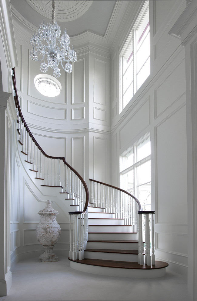 Exemple d'un très grand escalier peint courbe chic avec des marches en bois et éclairage.