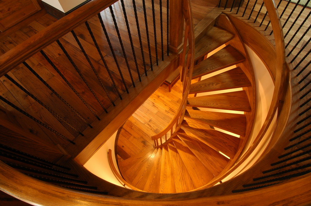 Ejemplo de escalera curva tradicional con escalones de madera y contrahuellas de madera