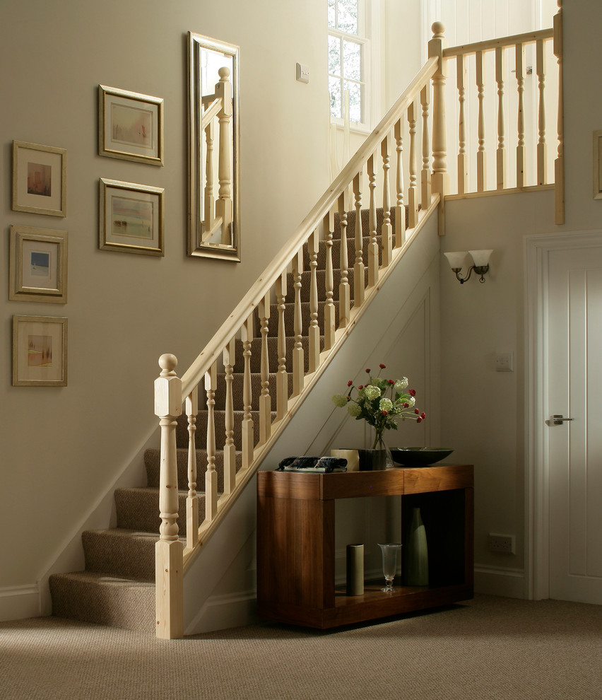 Victorian carpeted straight wood railing staircase with carpeted risers.