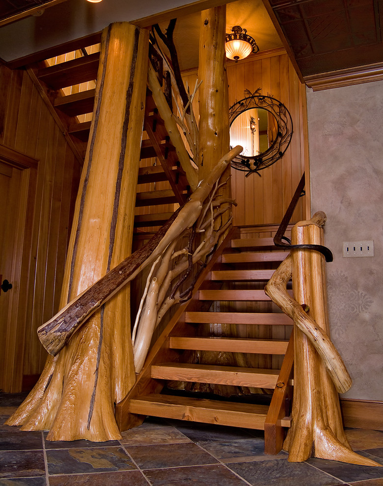 Large rustic wood u-shaped staircase in New York with wood risers.