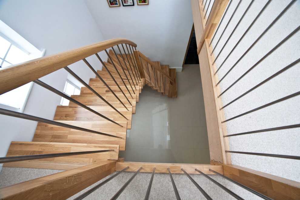 На фото: угловая лестница среднего размера в современном стиле с деревянными ступенями без подступенок
