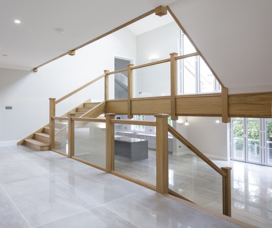 Modelo de escalera recta contemporánea de tamaño medio con escalones de madera, contrahuellas de madera y barandilla de varios materiales