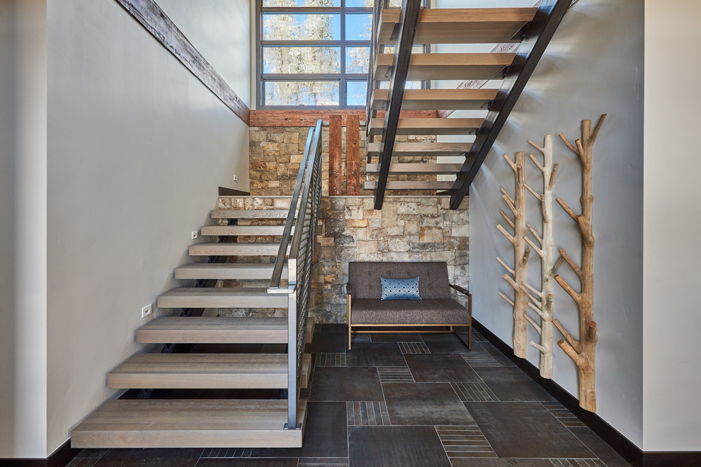 На фото: большая п-образная лестница в современном стиле с металлическими перилами и деревянными ступенями без подступенок