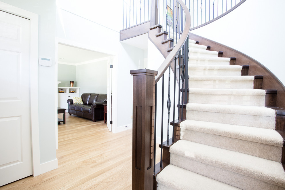 Mid-sized transitional carpeted curved staircase photo in Vancouver with wooden risers
