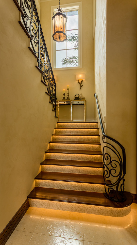 Idée de décoration pour un escalier méditerranéen avec des marches en bois et des contremarches carrelées.