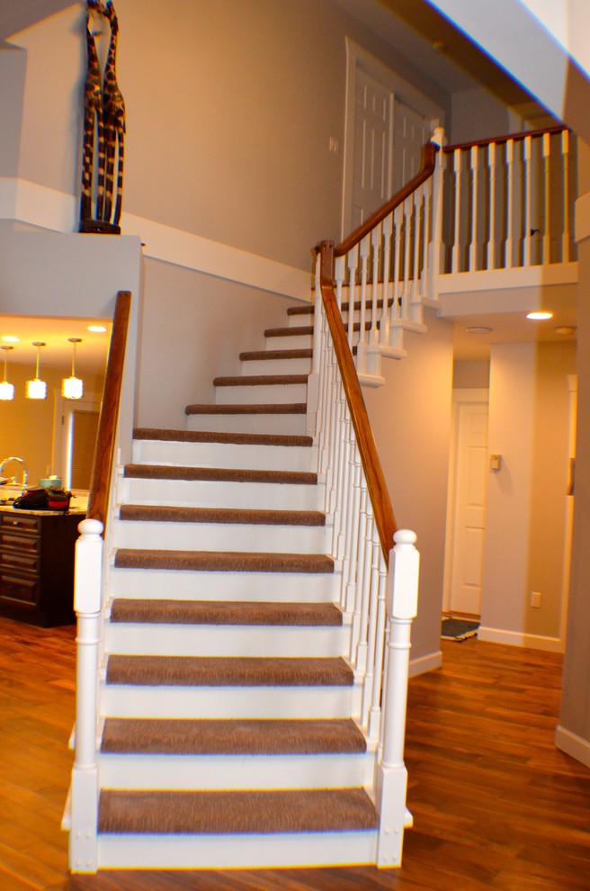Aménagement d'un escalier courbe classique de taille moyenne avec des marches en moquette et des contremarches en bois.