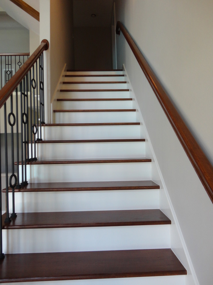 Imagen de escalera recta clásica grande con escalones de madera pintada y contrahuellas de madera