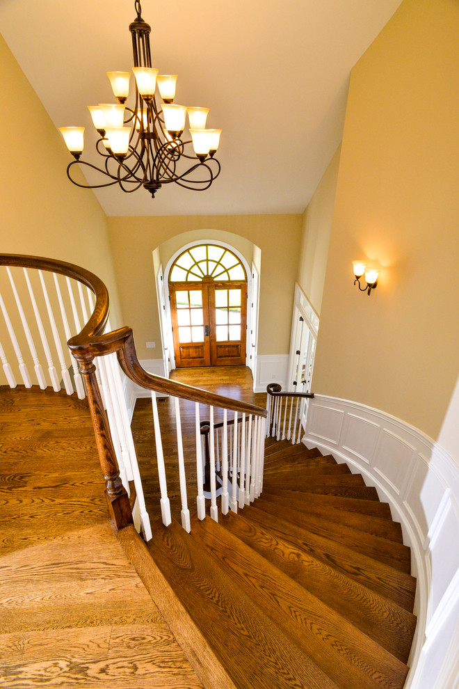 Inspiration for a large timeless wooden curved staircase remodel in DC Metro with wooden risers