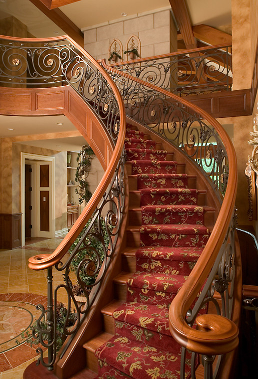 Идея дизайна: огромная изогнутая металлическая лестница в классическом стиле с ступенями с ковровым покрытием
