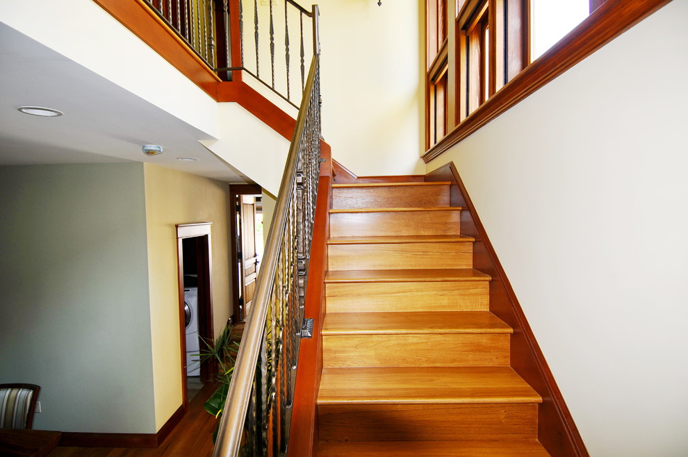 Idée de décoration pour un escalier ethnique en U de taille moyenne avec des marches en bois, des contremarches en bois et un garde-corps en métal.
