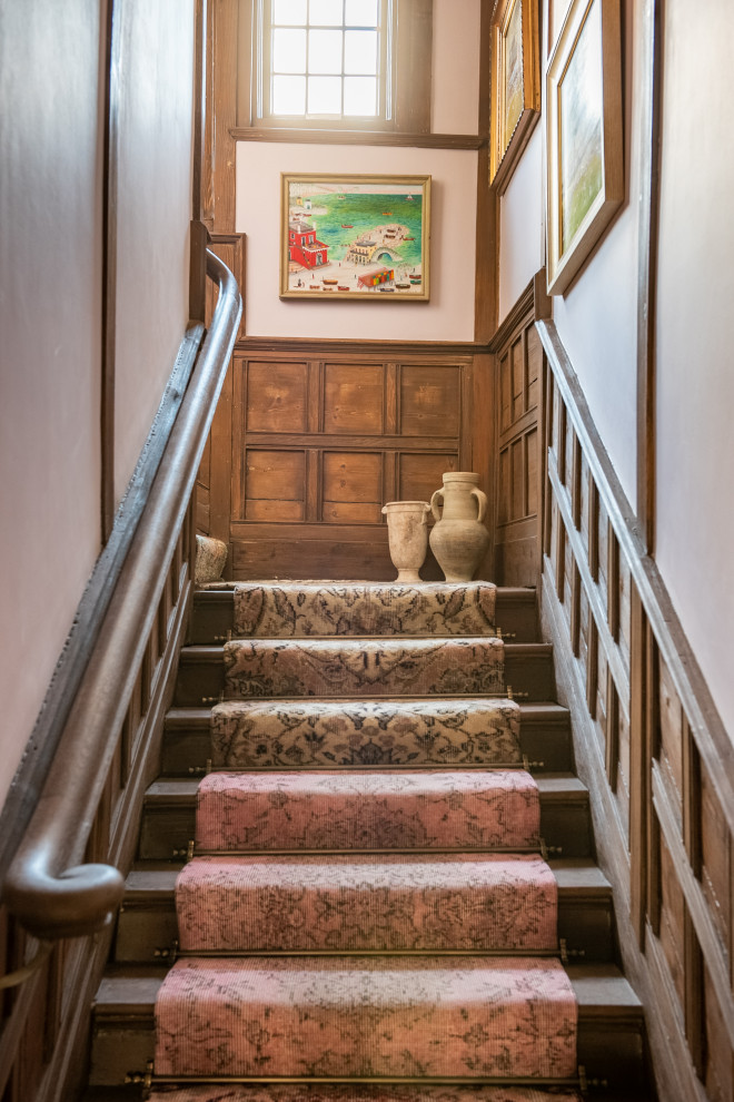 Staircase - mid-sized eclectic wooden u-shaped wood railing and wall paneling staircase idea in London with carpeted risers