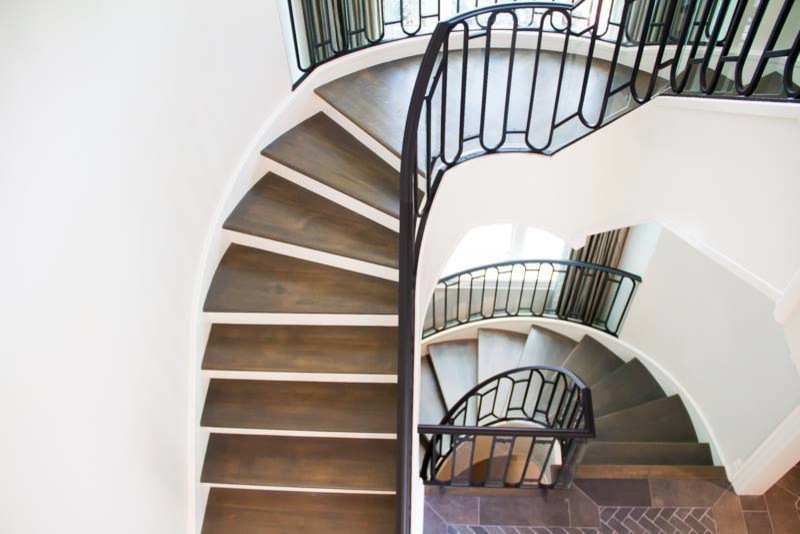 Идея дизайна: огромная изогнутая лестница в стиле кантри с деревянными ступенями
