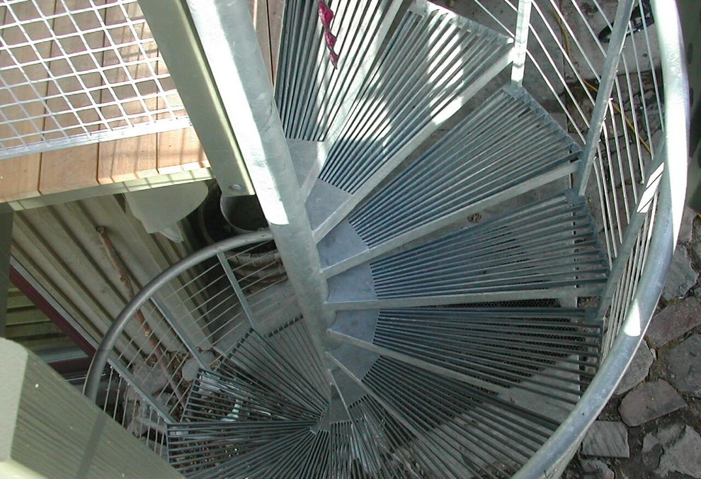 На фото: винтовая металлическая лестница среднего размера с металлическими ступенями с