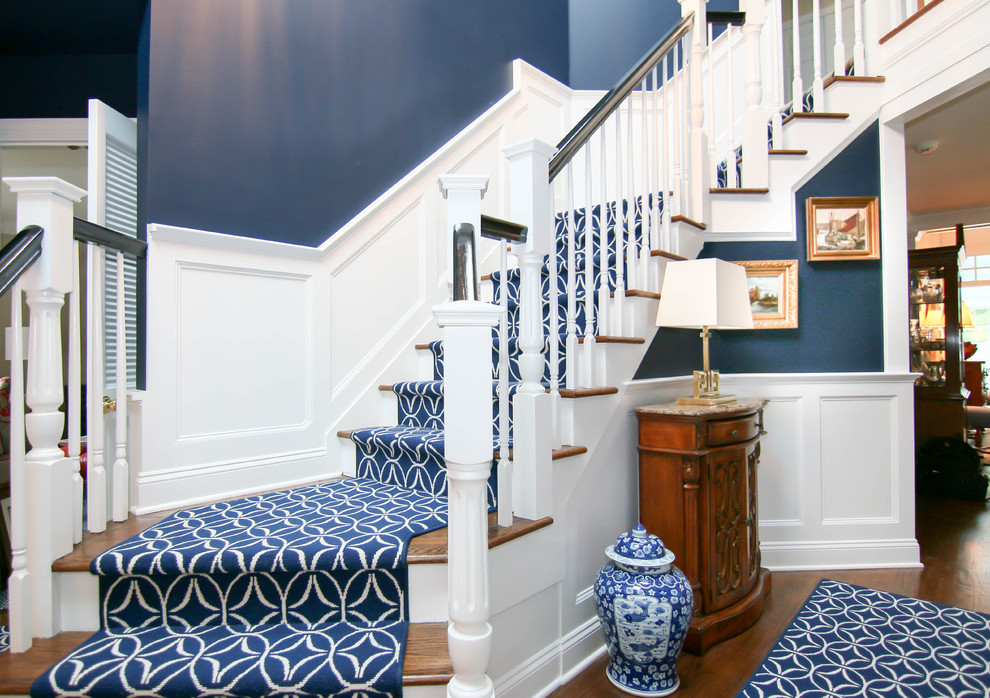 Photo of a classic wood staircase in New York with painted wood risers and a dado rail.