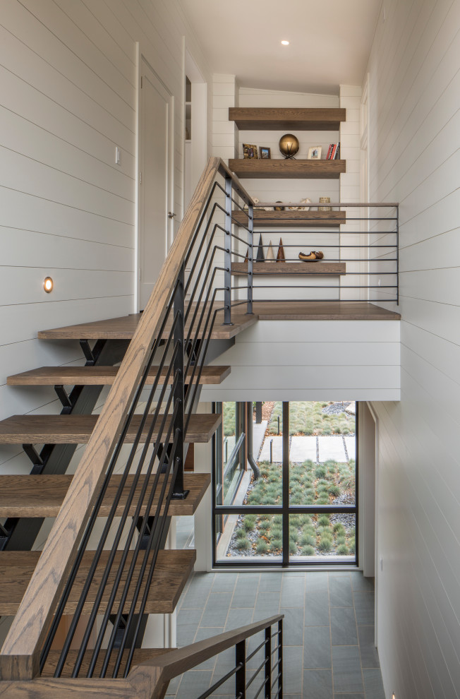 Ejemplo de escalera en U moderna de tamaño medio sin contrahuella con escalones de madera y barandilla de metal