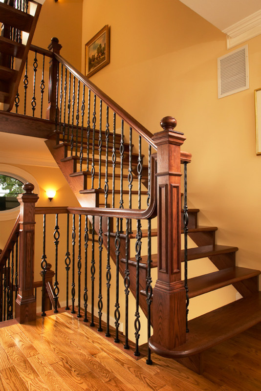 Foto de escalera curva tradicional grande sin contrahuella con escalones de madera y barandilla de varios materiales