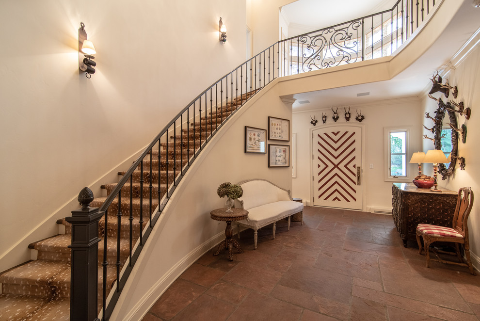 Huge ornate wooden curved metal railing staircase photo in Denver with wooden risers