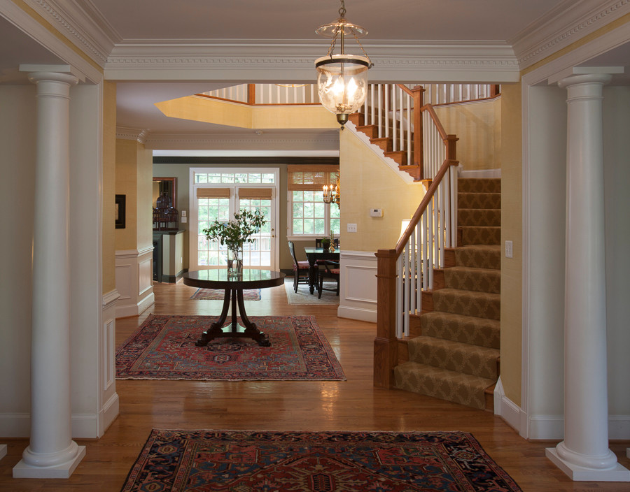 Idée de décoration pour un grand escalier tradition en L avec des marches en bois et des contremarches en bois.