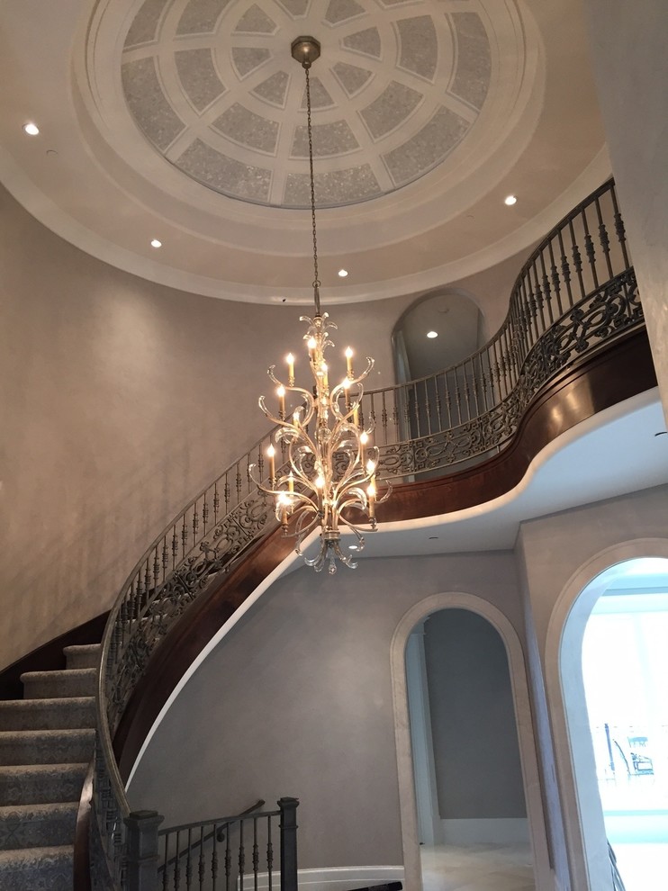 Photo of a large traditional carpeted curved metal railing staircase in Salt Lake City with carpeted risers.
