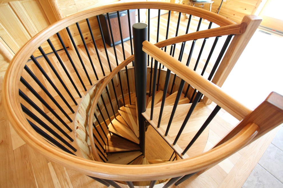 Imagen de escalera de caracol tradicional pequeña con escalones de madera y contrahuellas de metal