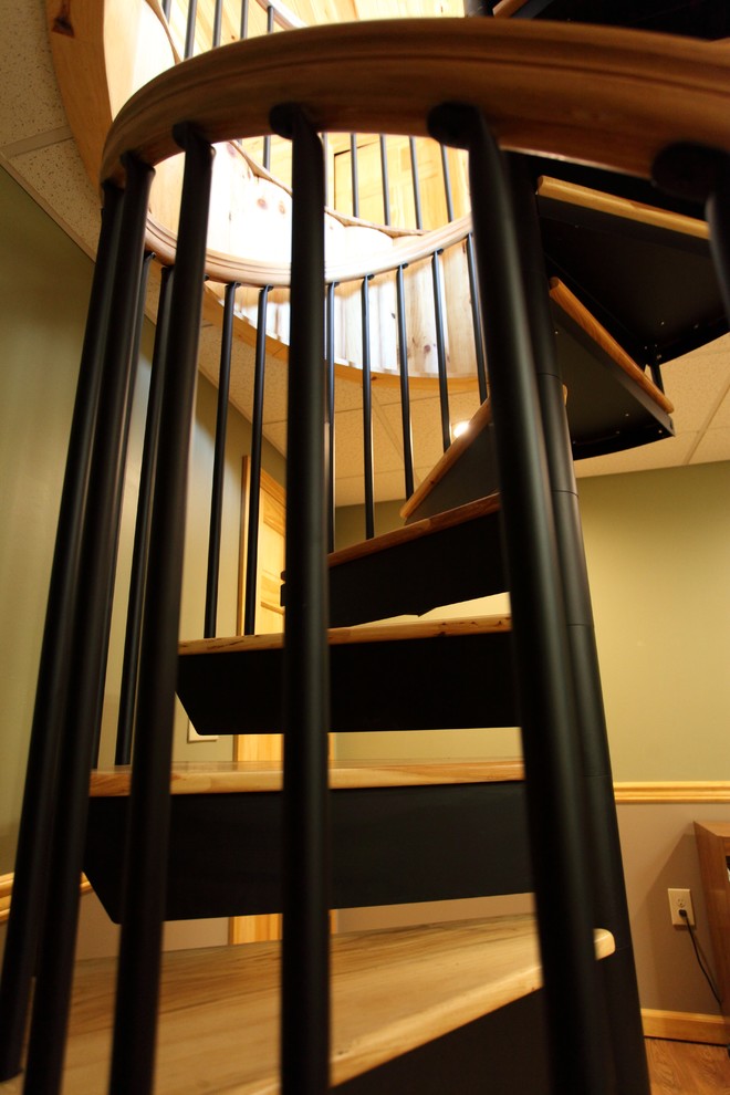 Imagen de escalera de caracol clásica pequeña con escalones de madera y contrahuellas de metal