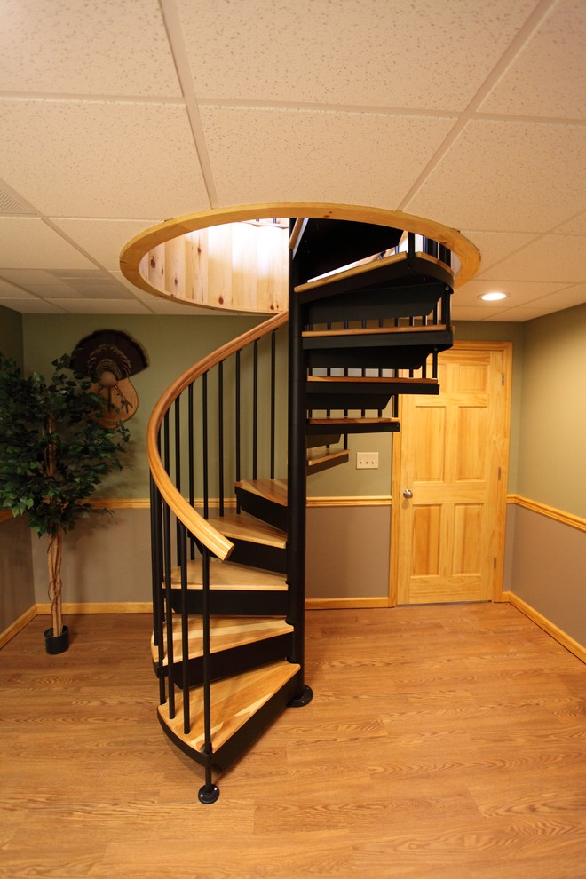 Ejemplo de escalera de caracol clásica pequeña con escalones de madera y contrahuellas de metal