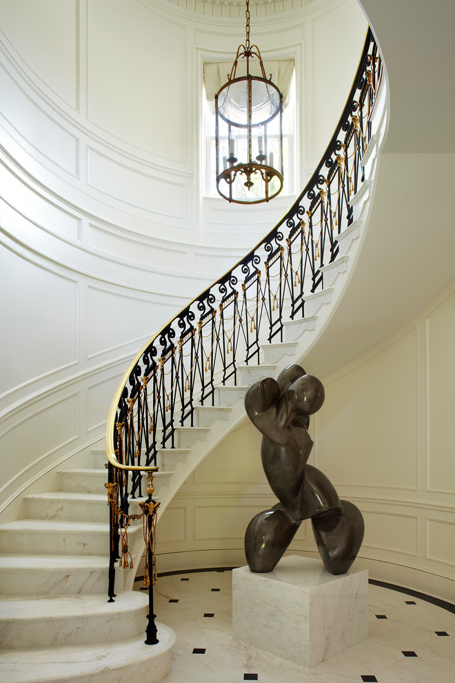 Источник вдохновения для домашнего уюта: огромная изогнутая лестница в классическом стиле с мраморными ступенями и подступенками из мрамора