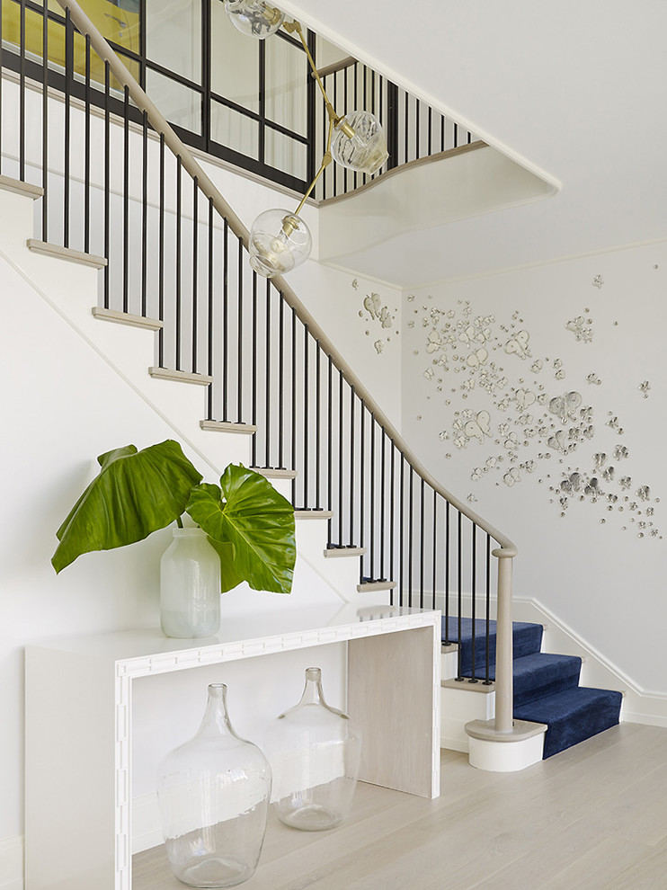 На фото: изогнутая лестница в морском стиле с ступенями с ковровым покрытием, ковровыми подступенками и перилами из смешанных материалов с