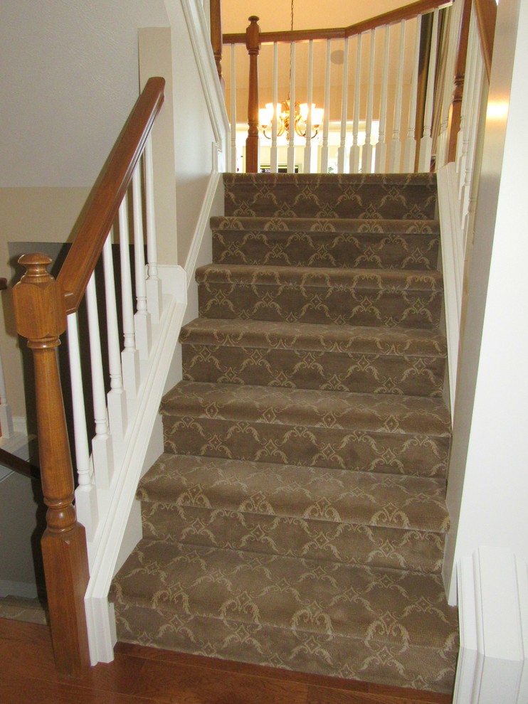 На фото: угловая лестница среднего размера в классическом стиле с ступенями с ковровым покрытием и ковровыми подступенками
