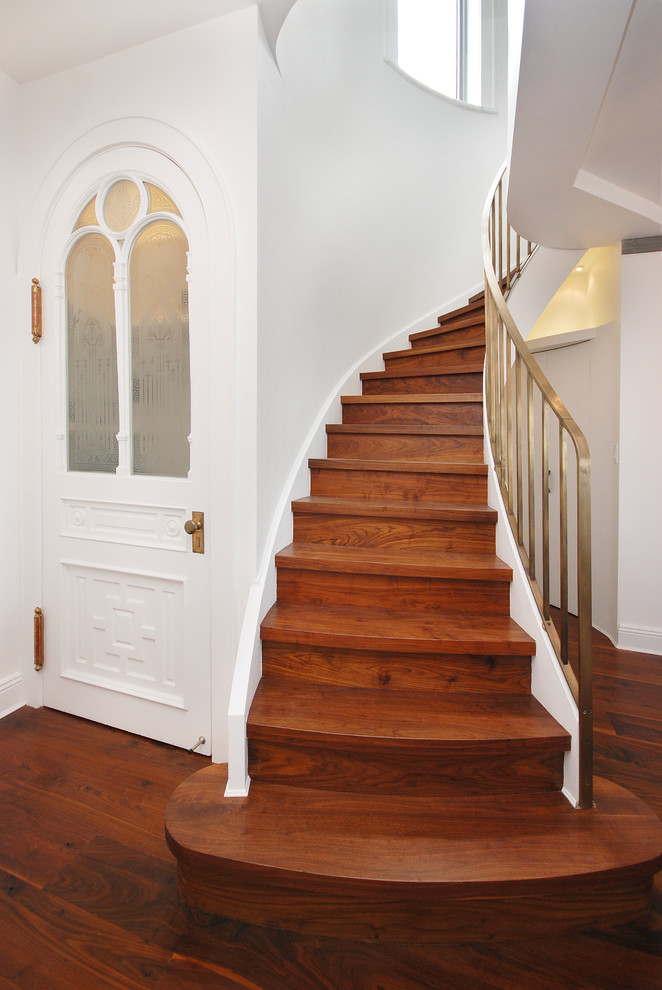 Cette image montre un escalier courbe traditionnel avec des marches en bois et des contremarches en bois.