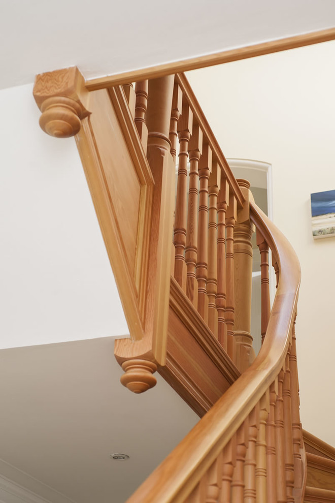 Inspiration pour un escalier courbe traditionnel de taille moyenne avec des marches en bois et des contremarches en bois.