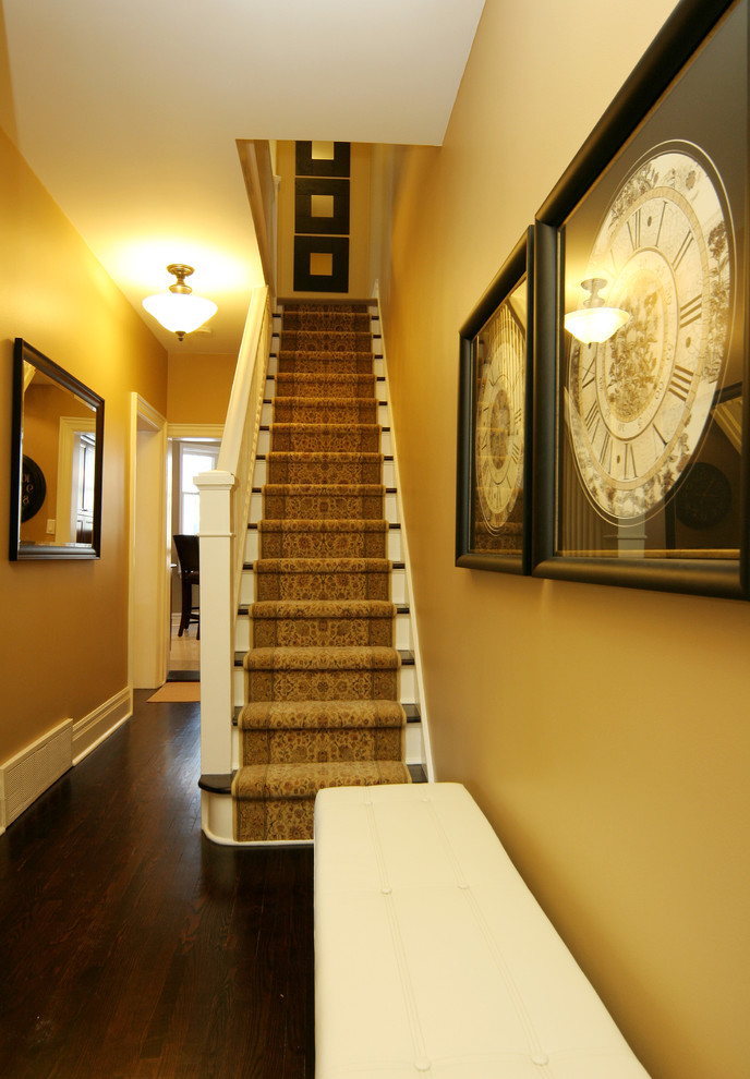 Aménagement d'un escalier classique avec des marches en bois et éclairage.