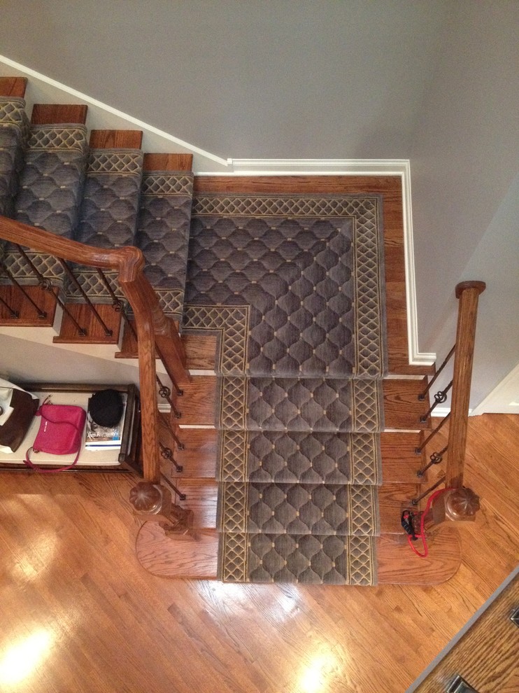Exempel på en stor klassisk svängd trappa, med heltäckningsmatta och sättsteg med heltäckningsmatta