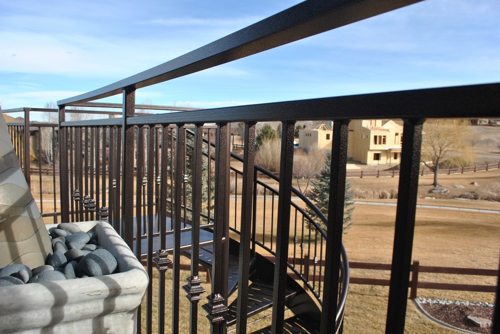 Medium sized classic metal spiral metal railing staircase in Denver with open risers.