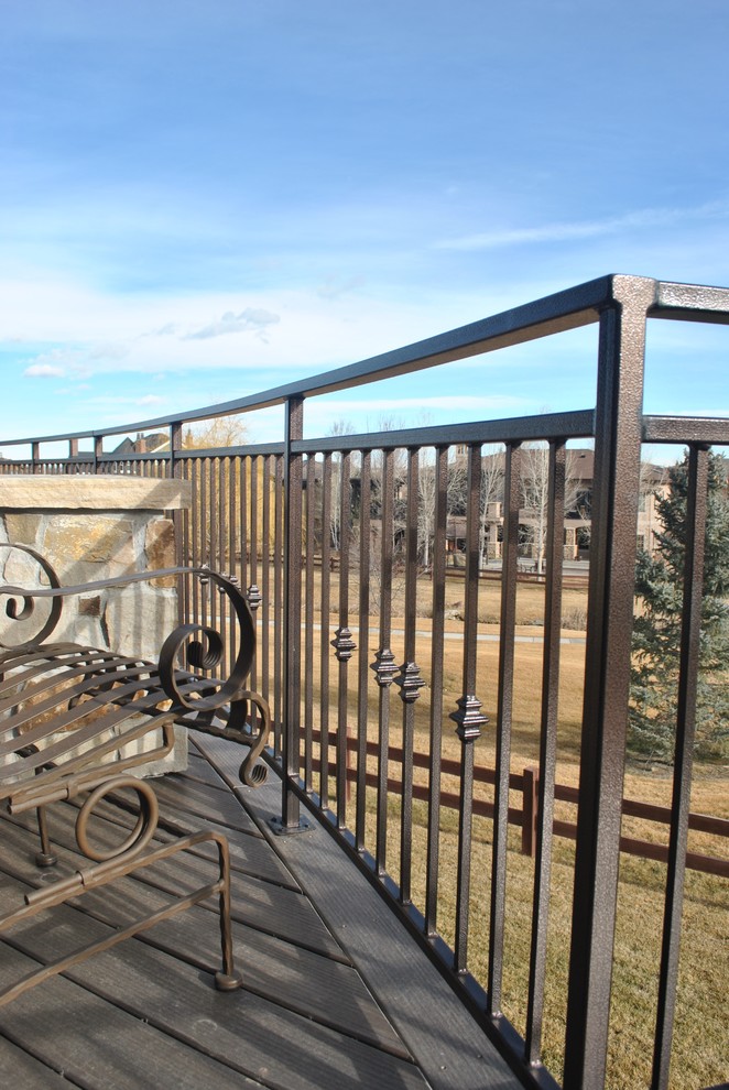 This is an example of a medium sized traditional metal spiral metal railing staircase in Denver with open risers.