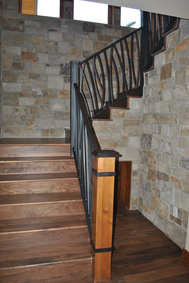 Diseño de escalera en L clásica de tamaño medio con escalones de madera, contrahuellas de madera y barandilla de metal
