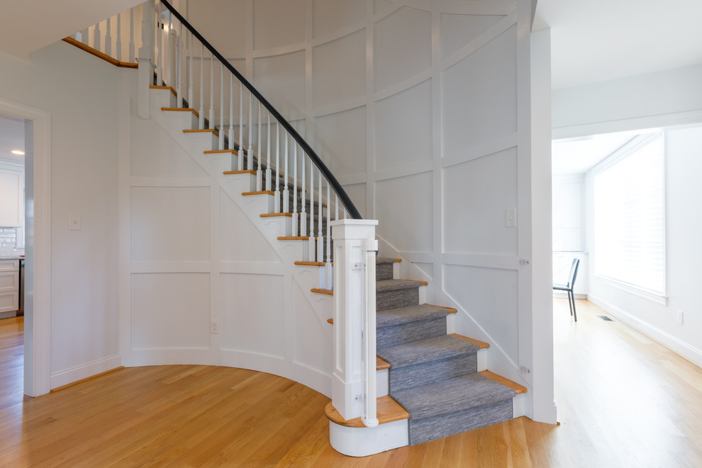 Photo of a classic wood curved wood railing staircase in Other with wood risers.
