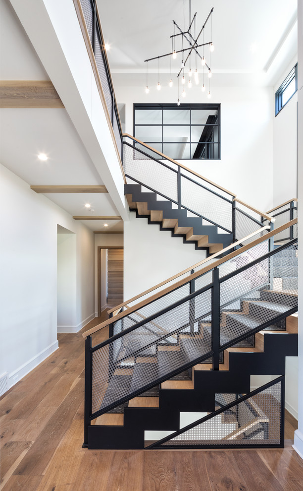 Ejemplo de escalera en U contemporánea con escalones de madera, contrahuellas de madera y barandilla de metal