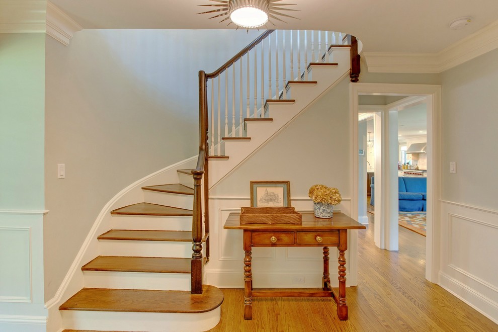 Inspiration for a large transitional painted curved staircase remodel in New York with wooden risers