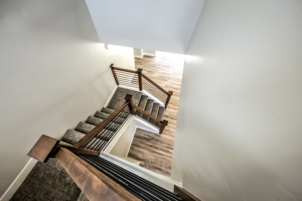 На фото: п-образная лестница среднего размера в стиле неоклассика (современная классика) с ступенями с ковровым покрытием, ковровыми подступенками и перилами из смешанных материалов с