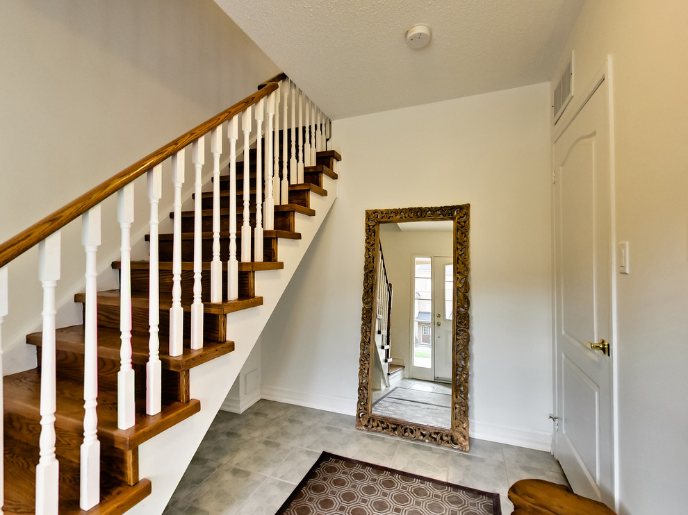 Medium sized classic wood straight wood railing staircase in Toronto with wood risers.
